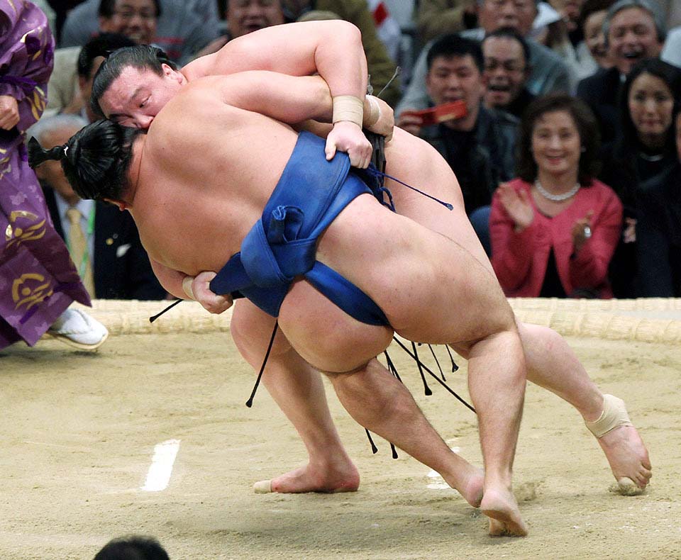 TOPSHOTS- "Yokozuna", or sumo grand champion, Hakuho from Mongolia (facing) throws compatriot Kakuryu to the dirt during their playoff bout at the Spring Grand Sumo tournament in Osaka on March 25, 2012. Hakuho won the tournament by winning the playoff after both wrestlers finished the 15-day tournament with equal 13-2 records. JAPAN OUT AFP PHOTO / JIJI PRESS