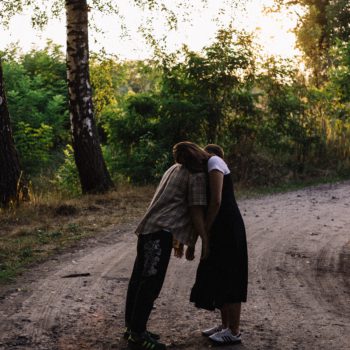 couple-hugging-while-standing-on-dirtway-3373377