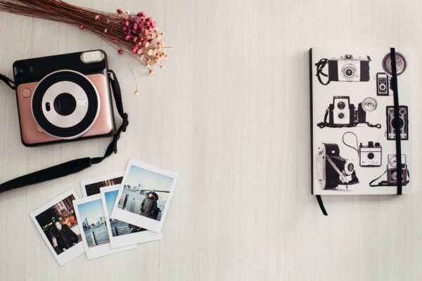 flat-lay-shot-of-camera-and-instant-photos-3915066